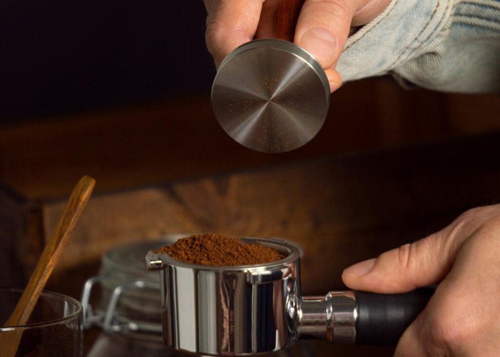 Man grinding coffee and indicating how many coffee beans per cup of coffee